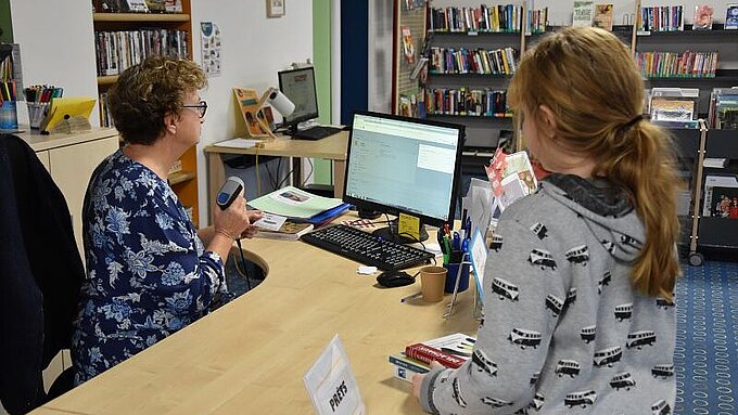 Enfant qui emprunte des livres à la bibliothèque de Couffé Enfant qui emprunte des livres à la bibliothèque de Couffé